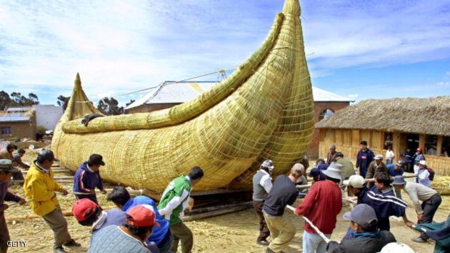 Citizens of Huatajata push a reed boat 25 August 2002 which they designed and built in hopes of being capable of carrying eight tons of stone 90 kms (56 miles) across Lake Titicaca. The University of Wisconsin at Madison, the University of Colorado, the Massachusetts Institute of Technology, and UMSA, the Bolivian university, are all taking part in the project. AFP PHOTO/Gonzalo ESPINOZA (Photo credit should read GONZALO ESPINOZA/AFP/Getty Images)