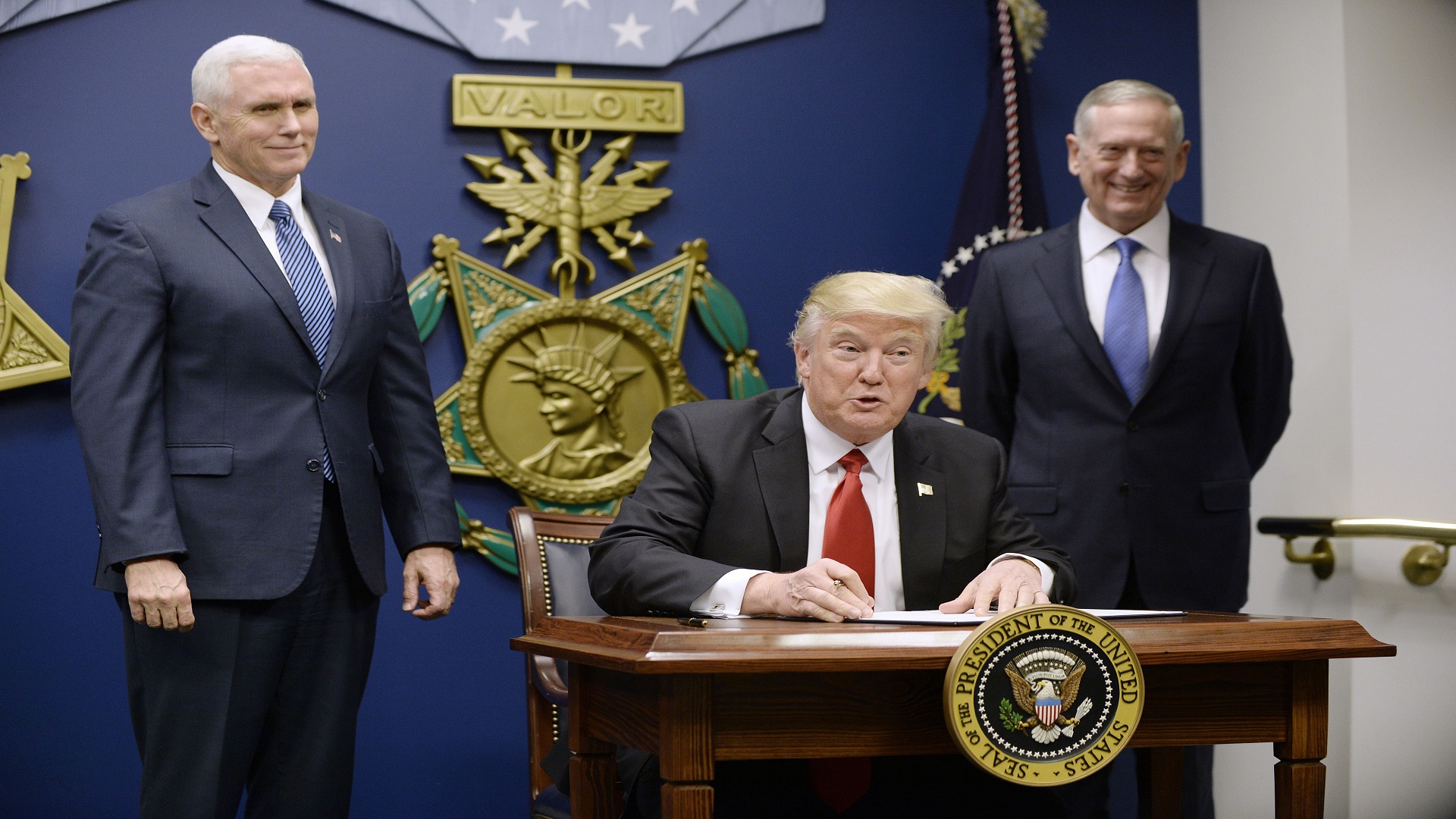 ARLINGTON, VA - JANUARY 27: U.S. President Donald Trump signs executive orders as Defense Secretary Gen. James Mattis and Vice President Mike Pence look on in the Hall of Heroes at the Department of Defense on January 27, 2017 in Arlington, Virginia. Trump signed two orders calling for the "great rebuilding" of the nation's military and the "extreme vetting" of visa seekers from terror-plagued countries. (Photo by Olivier Douliery-Pool/Getty Images)